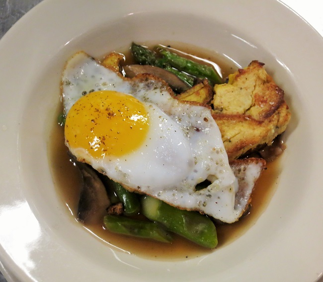 Cauliflower bread pudding, pan roasted and served on a portabello mushroom-asparagus-green garlic ragout with a fried duck egg