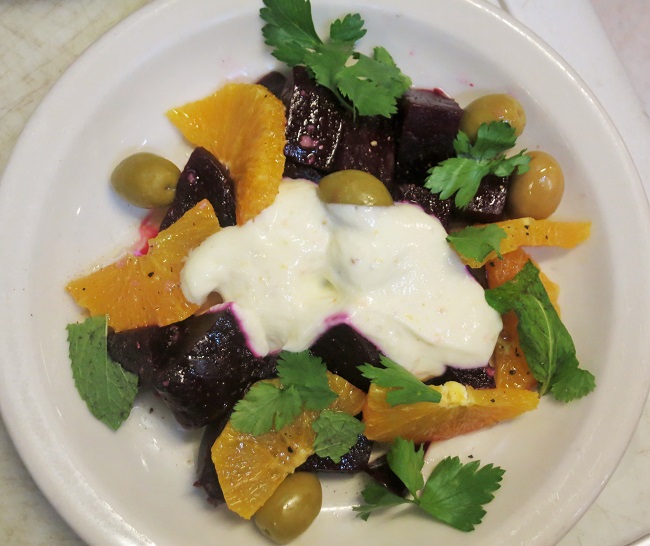 Moroccan-style beet salad with orange slices, picholine olives, parsley, mint, cilantro, olive oil, red wine vinegar and citrus-fennel pollen yogurt