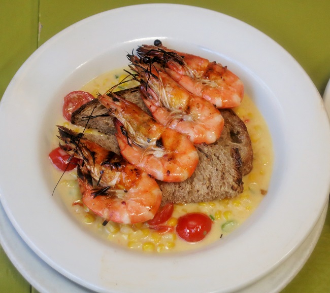 Grilled wild caught Gulf shrimp, served on a creamy ragout of sweet corn, cherry tomatoes, scallions and red chili flake, with garlic rubbed grilled bread